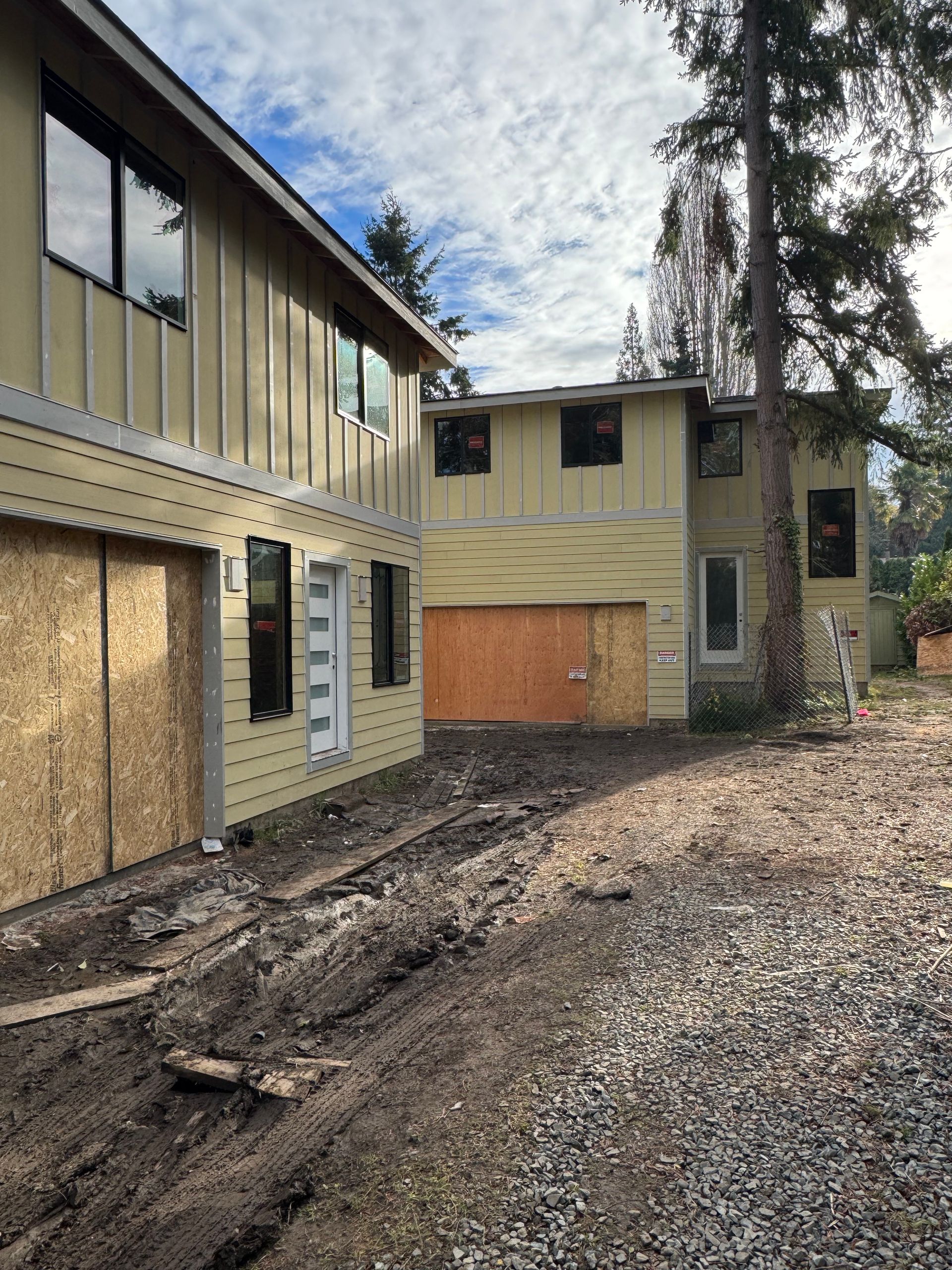A house with a garage and a lot of windows is being remodeled.