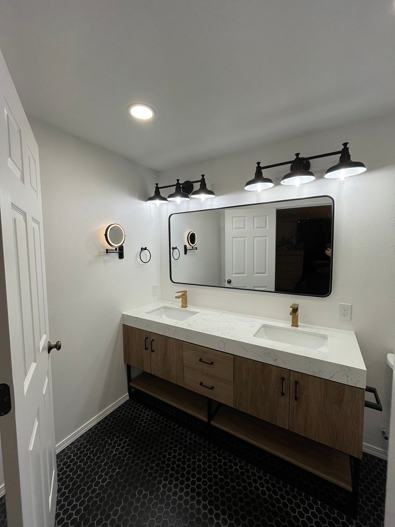 A bathroom with two sinks , a mirror and a toilet.
