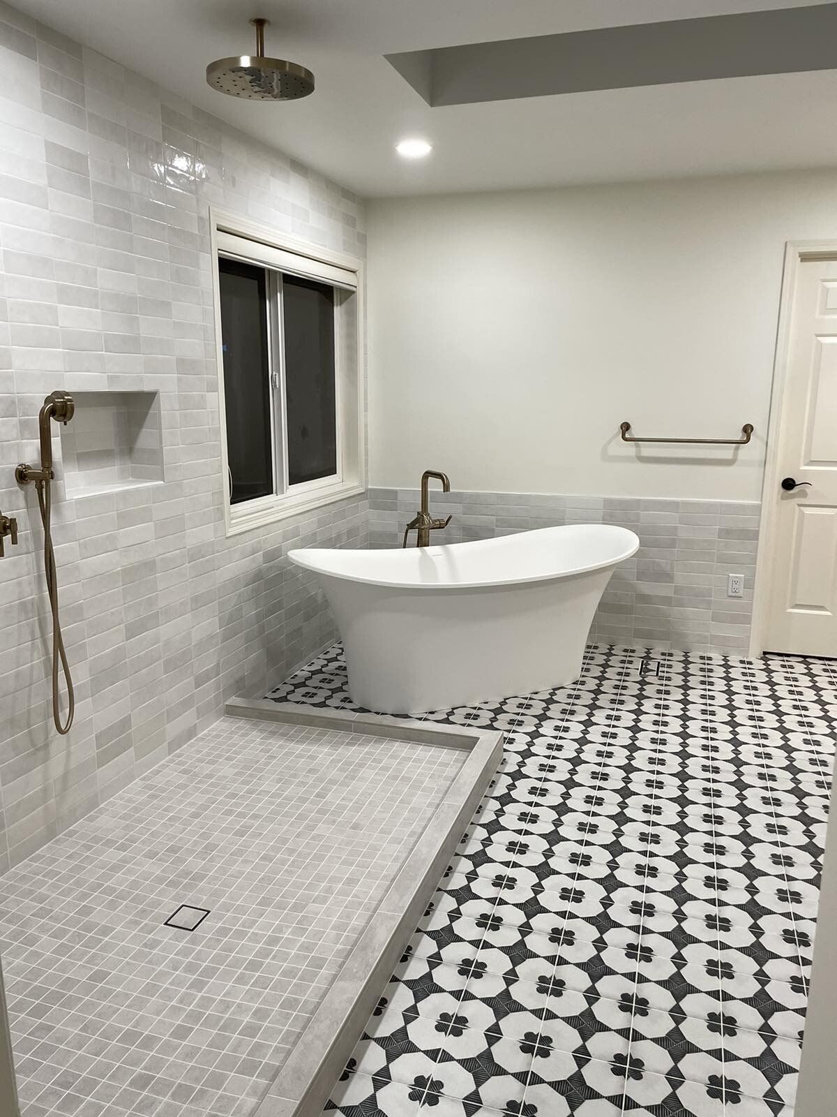 A bathroom with a tub , shower , and window.