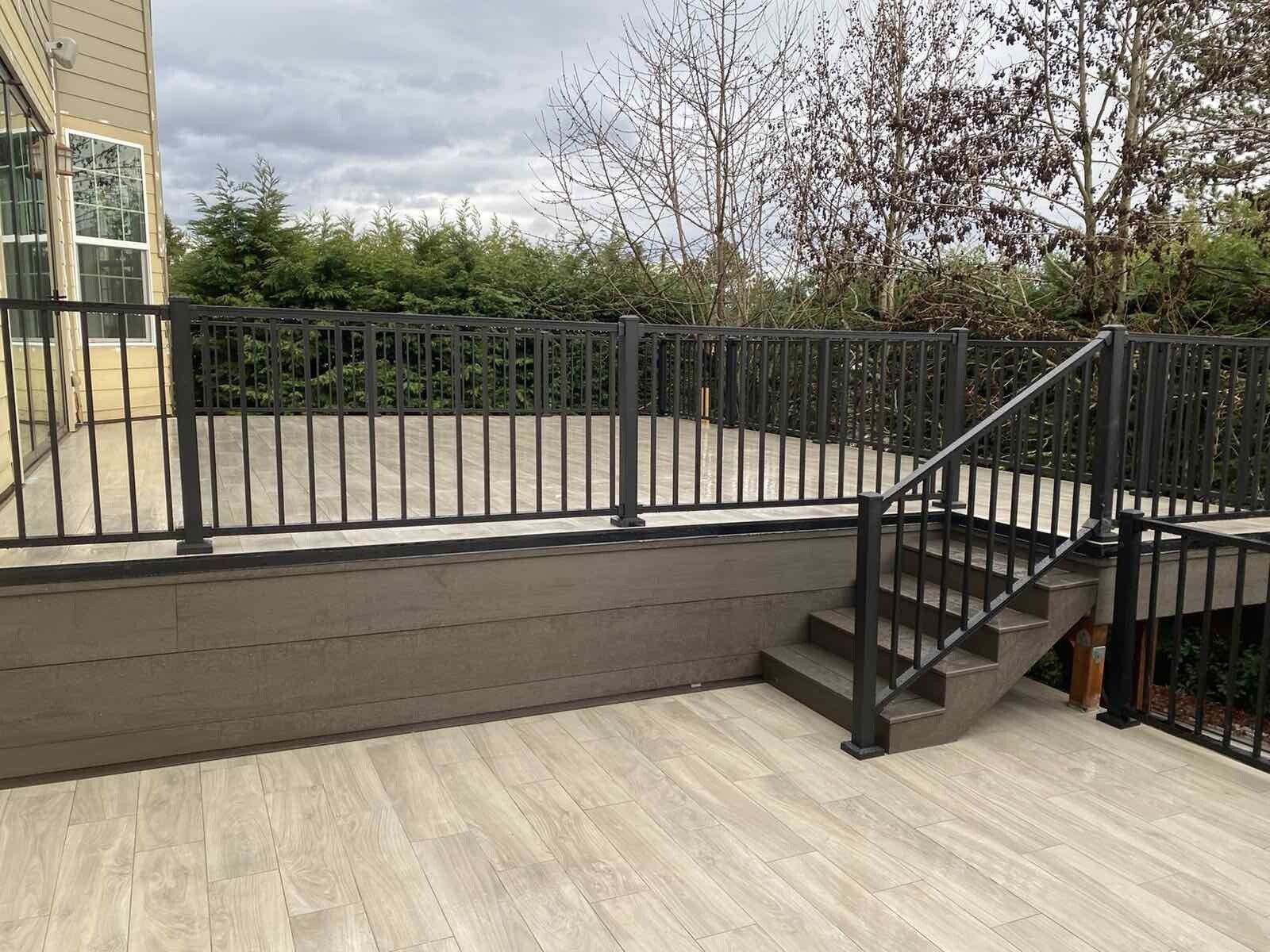 A wooden deck with stairs and a metal railing.