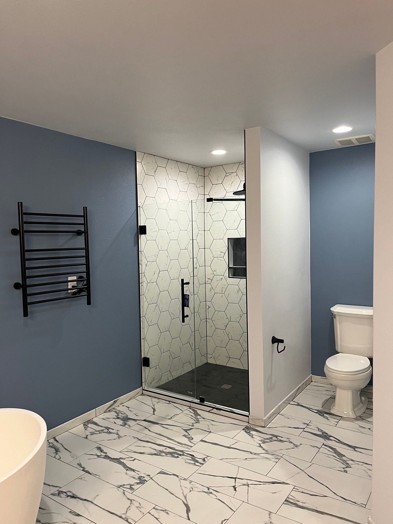 A bathroom with a walk in shower , toilet and bathtub.