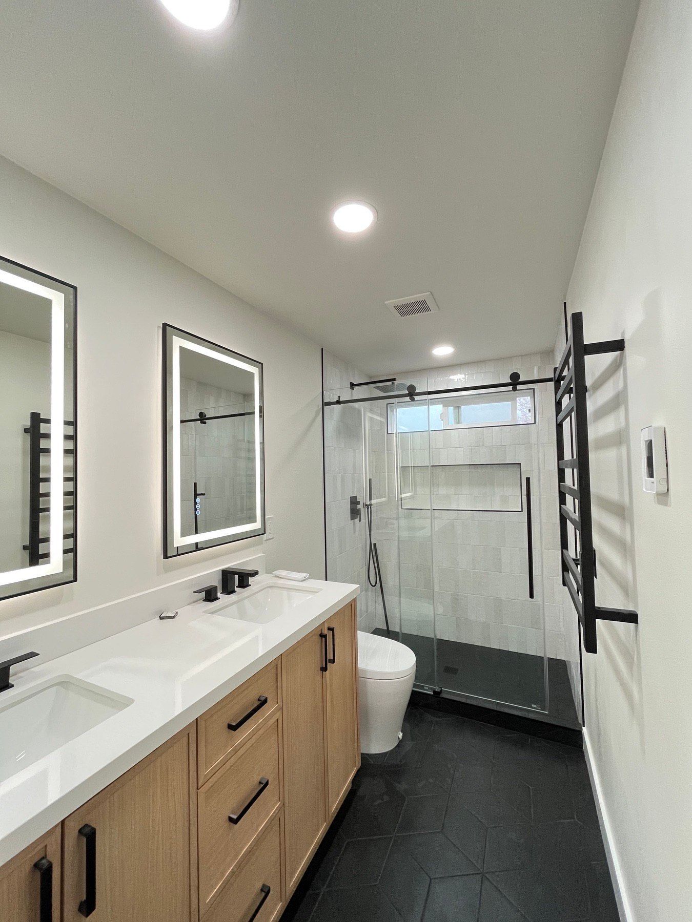 A bathroom with a toilet , sink and mirrors