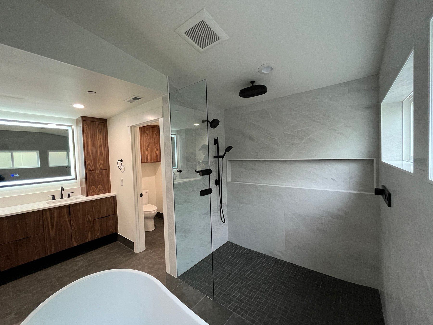 A bathroom with a walk in shower and a bathtub.