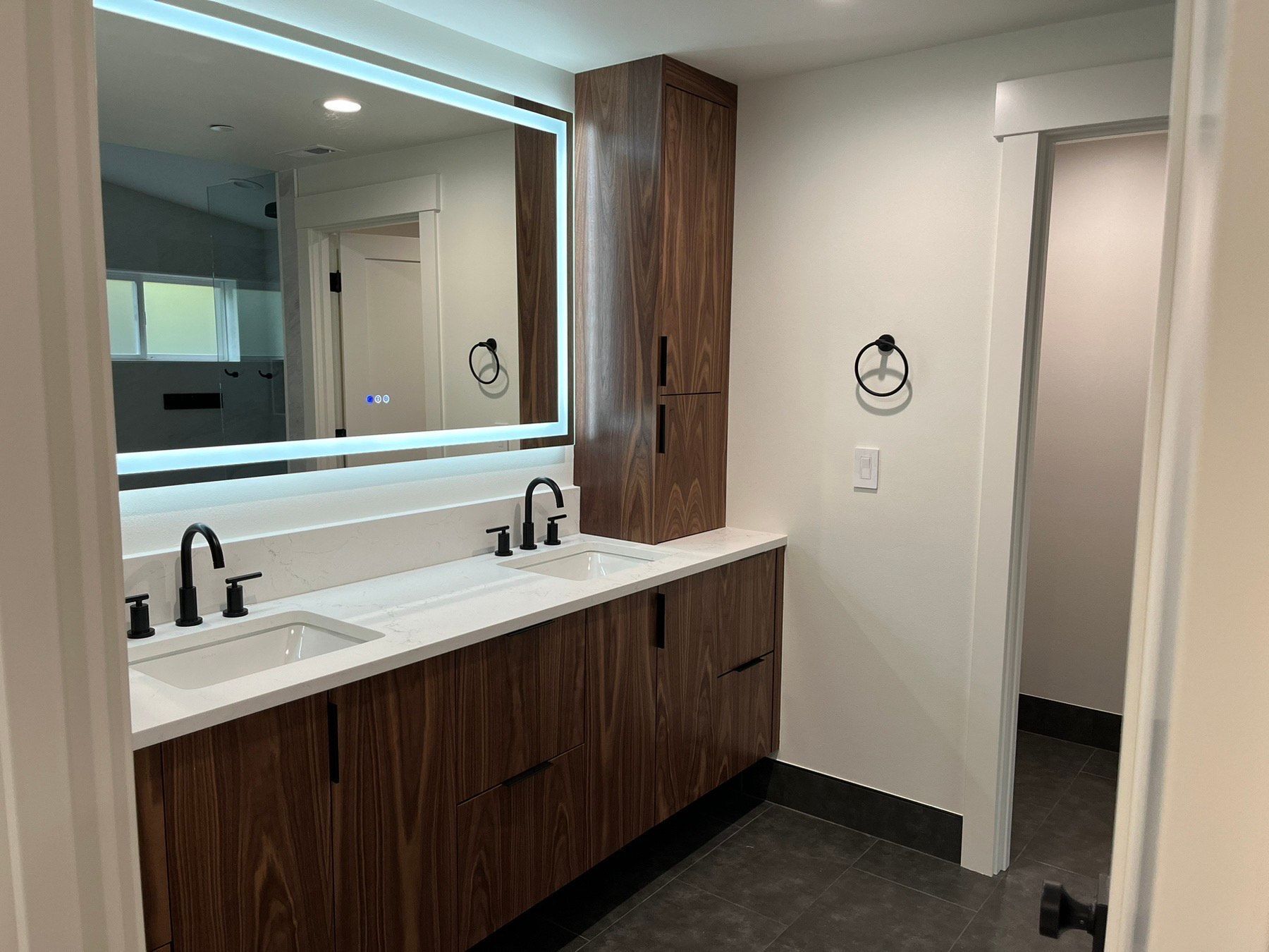 A bathroom with two sinks and a large mirror.