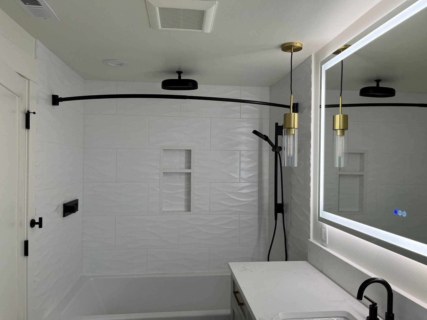 A bathroom with a tub , sink , mirror and shower.