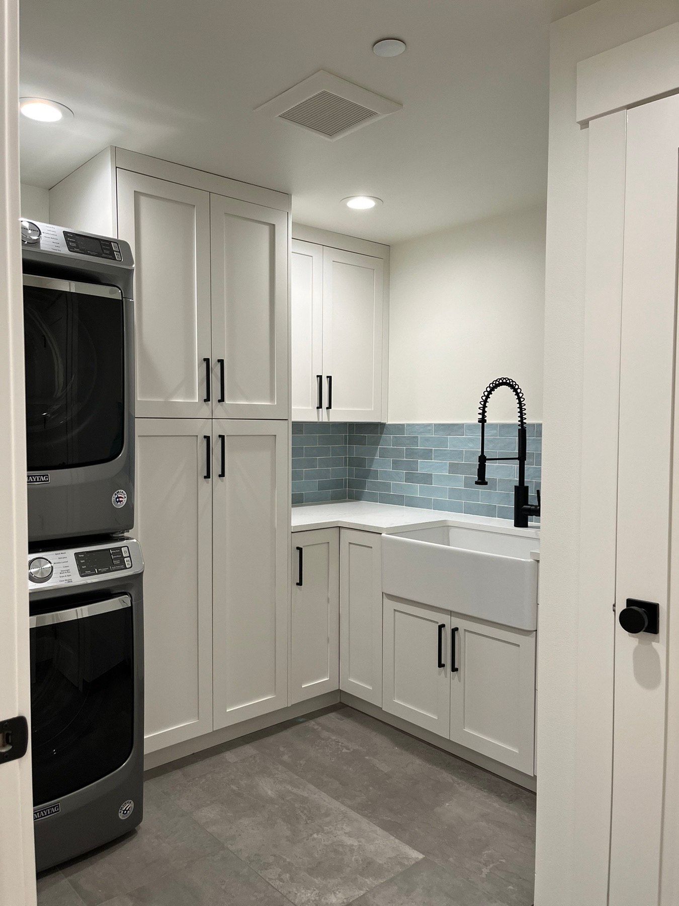 A laundry room with a washer and dryer and a sink