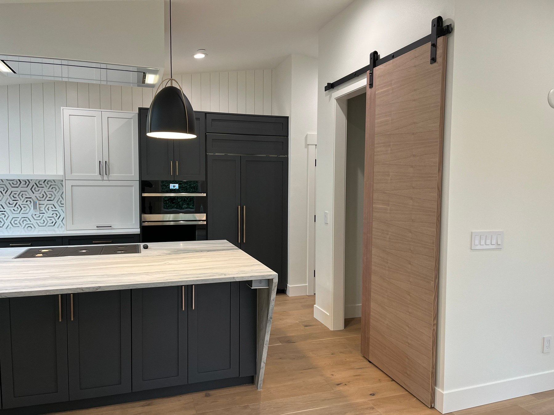 A kitchen with a sliding barn door and a large island.