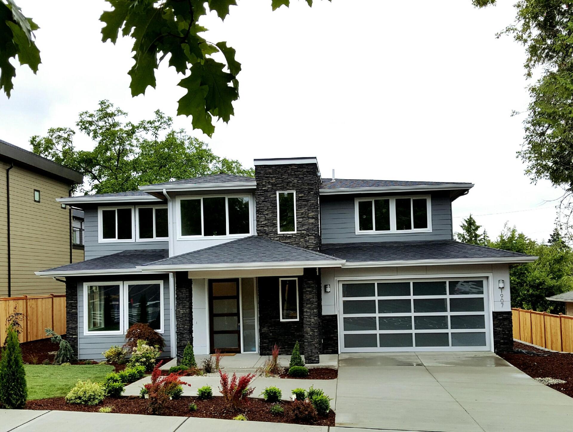 A large house with a garage and a lot of windows