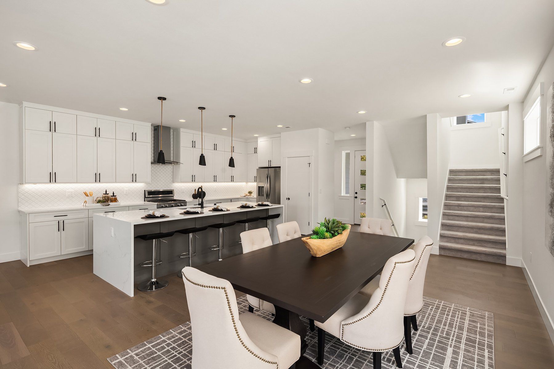 A kitchen and dining room in a house with a table and chairs.
