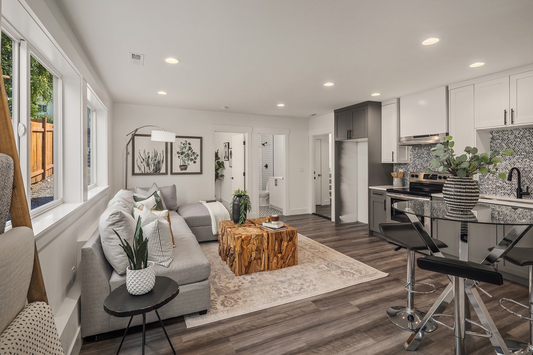 A living room with a couch , coffee table , and kitchen.