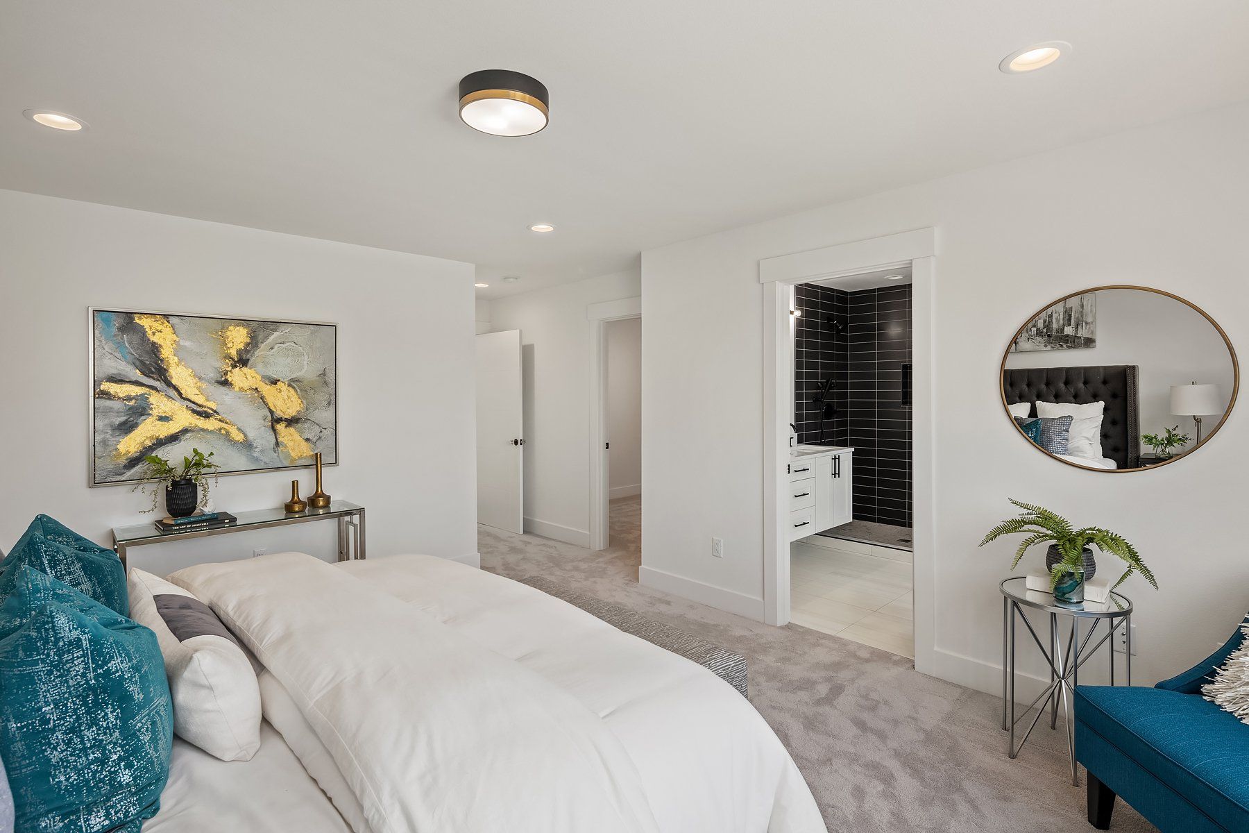 A bedroom with a bed , chair , table and mirror.