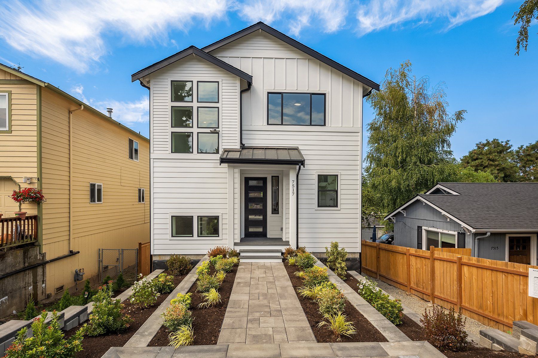 A white house with a wooden fence in front of it.