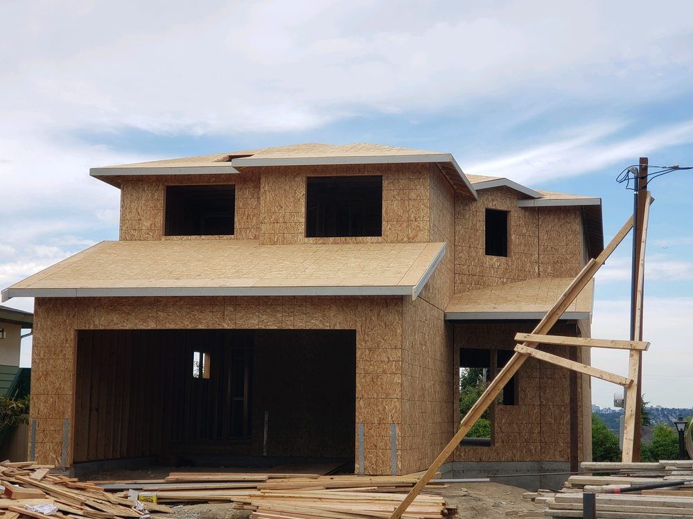 A house under construction with a lot of wood in front of it