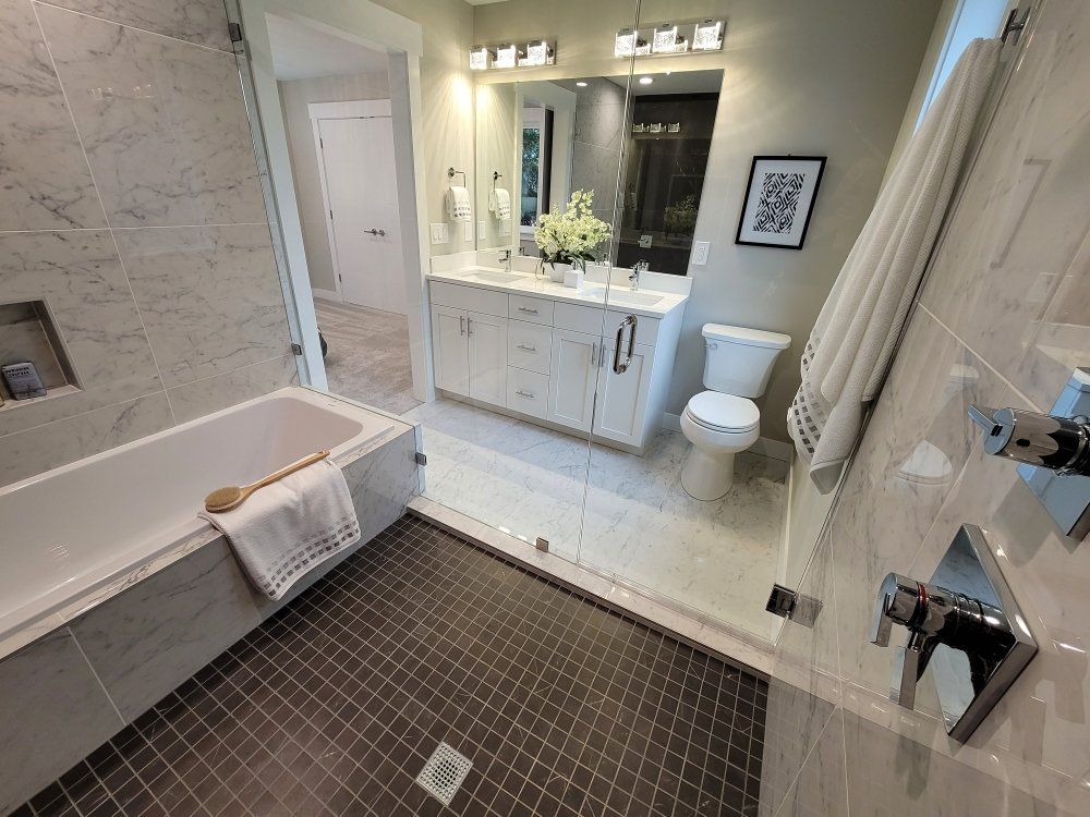A bathroom with a tub , toilet , sink and mirror.