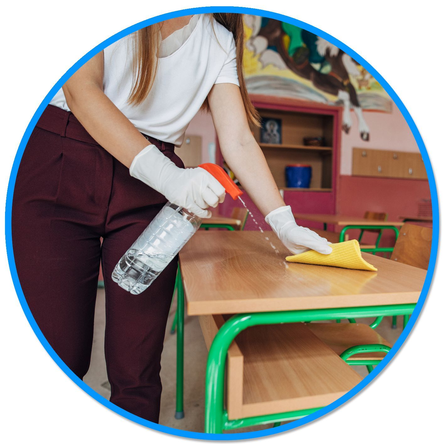 A woman is cleaning a desk with a spray bottle