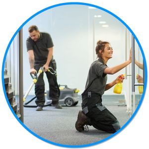 A man and a woman are cleaning a room with a vacuum cleaner