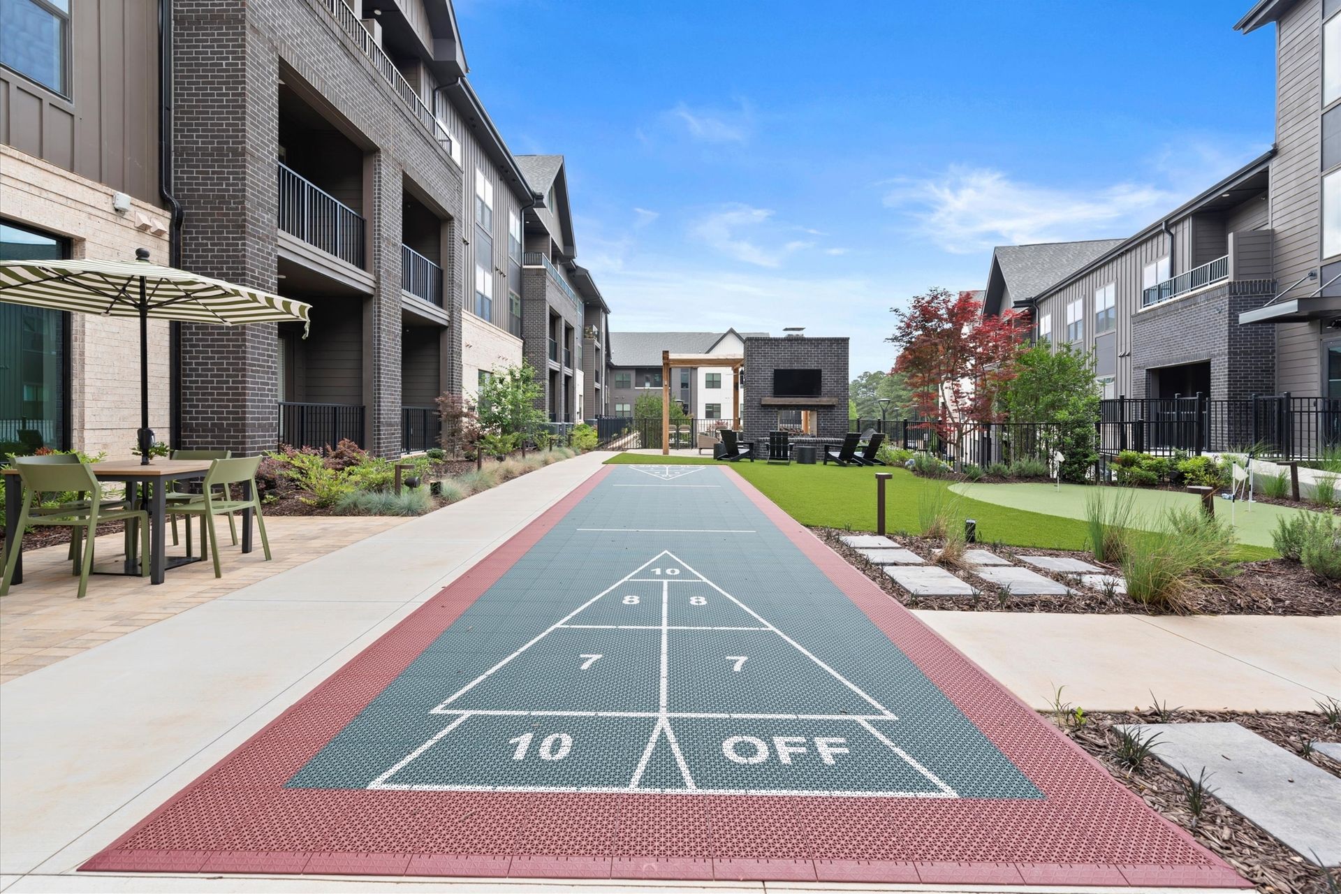 Shuffleboard court between apartment buildings on a sunny day.
