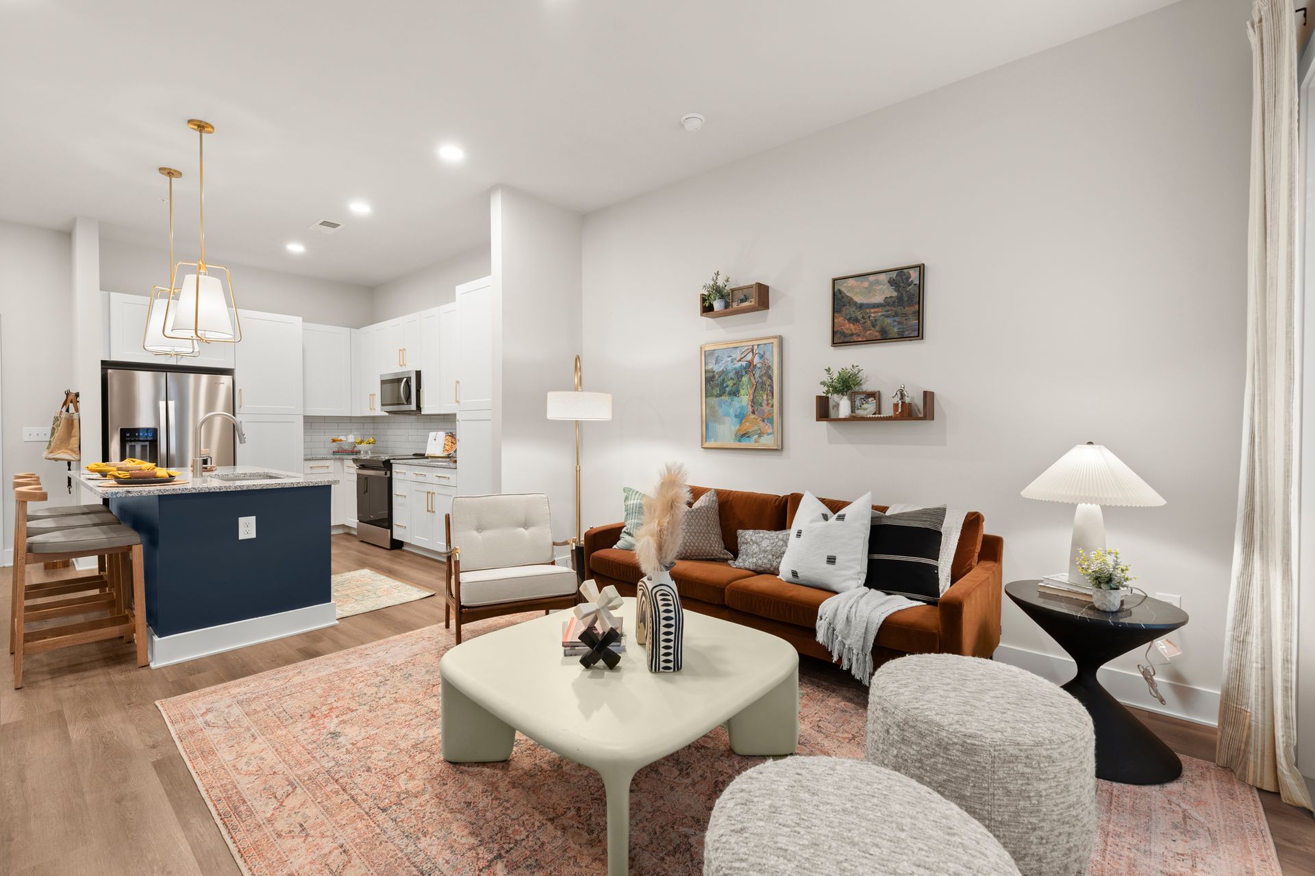 Modern living room with brown couch, blue island, and neutral décor.
