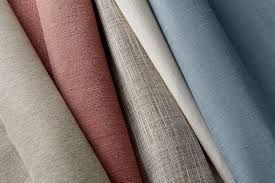 A close up of a bunch of different colored fabrics stacked on top of each other.