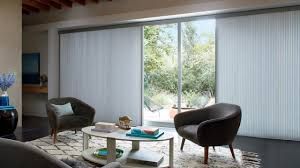 A living room with a table , chairs , and sliding glass doors.