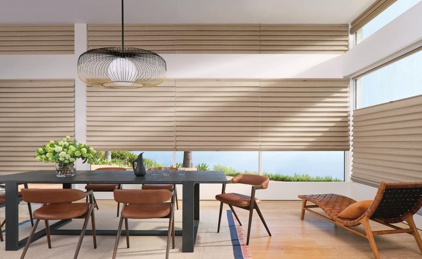 A dining room with a table and chairs and blinds on the windows.