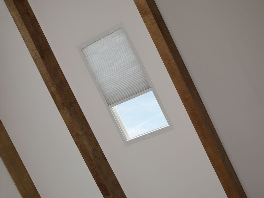 A skylight with a window and wooden beams on the ceiling.