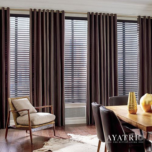 A living room with a dining table , chairs , curtains and blinds.