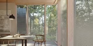 A dining room with a table and chairs and sliding glass doors.