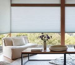 A living room with a couch , coffee table , and window shades.