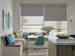 A kitchen with a table and chairs and a window with blinds.