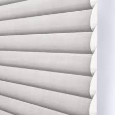 A close up of a white blind on a window.