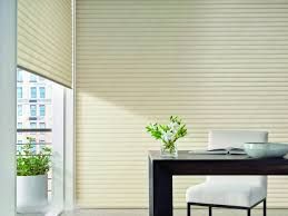 A dining room with a table and chairs and a window with blinds.