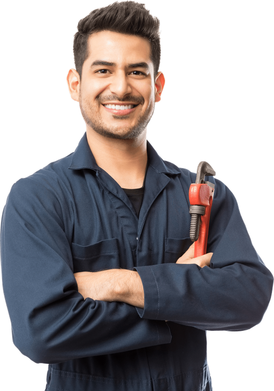 A man in a blue jumpsuit is holding a wrench and smiling.