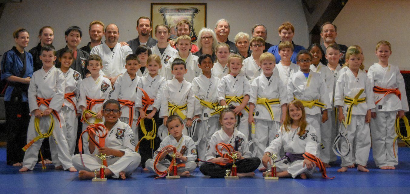 A group of people in karate uniforms are posing for a picture.