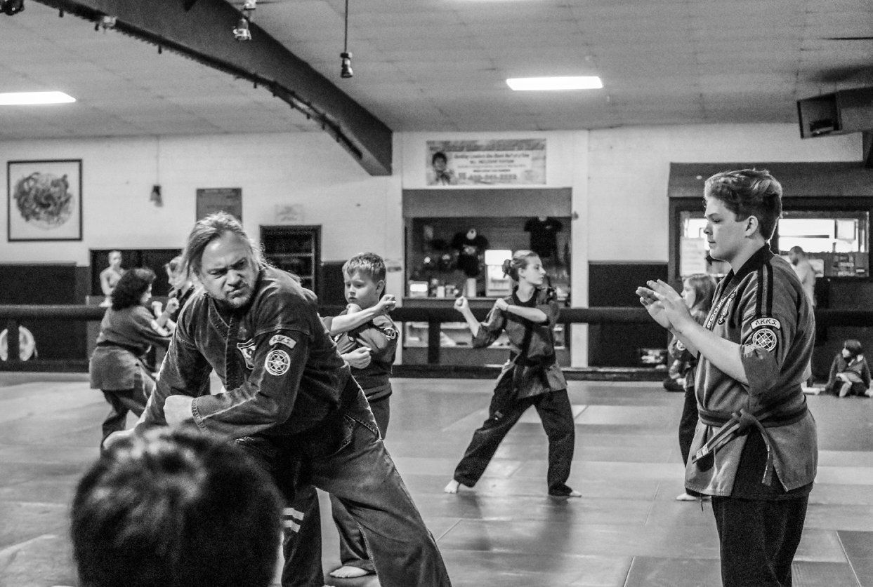 A group of people are practicing martial arts in a gym.