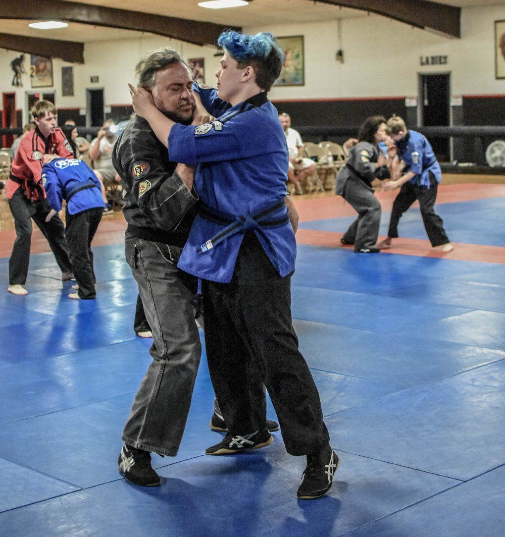 A group of people are practicing martial arts on a blue mat