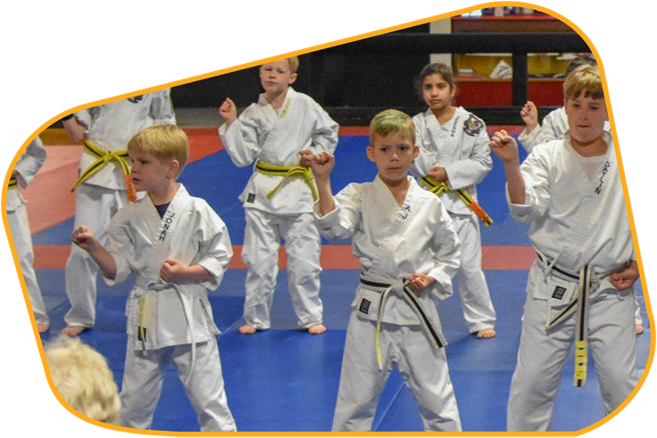 A group of young boys are practicing karate in a gym