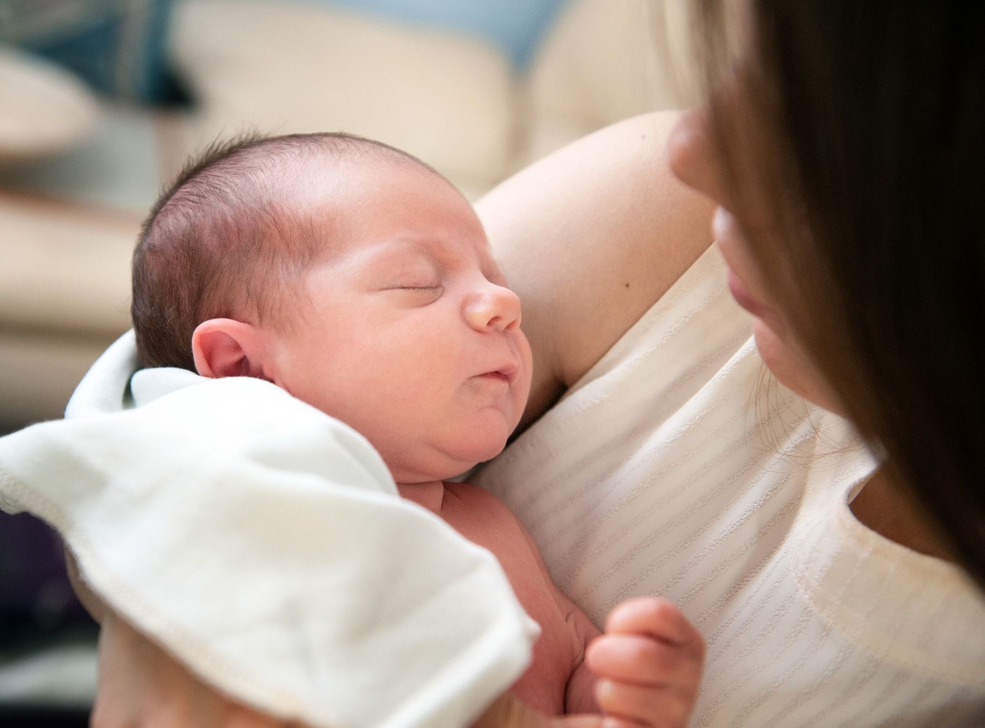 A woman is holding a newborn baby in her arms.