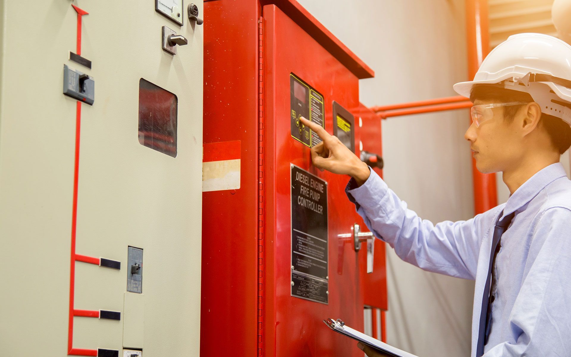 A man is working on a fire alarm system in a building.