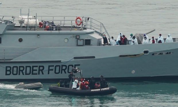 A group of people are in a boat in the ocean.