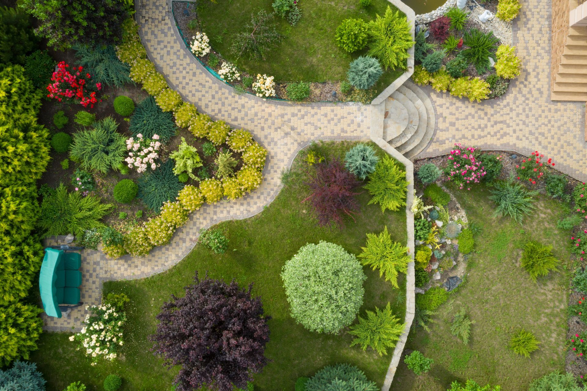 A garden view taken from above, with walkways and green grass.
