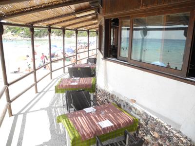 tavolini all`aperto sotto una tettoia fronte mare