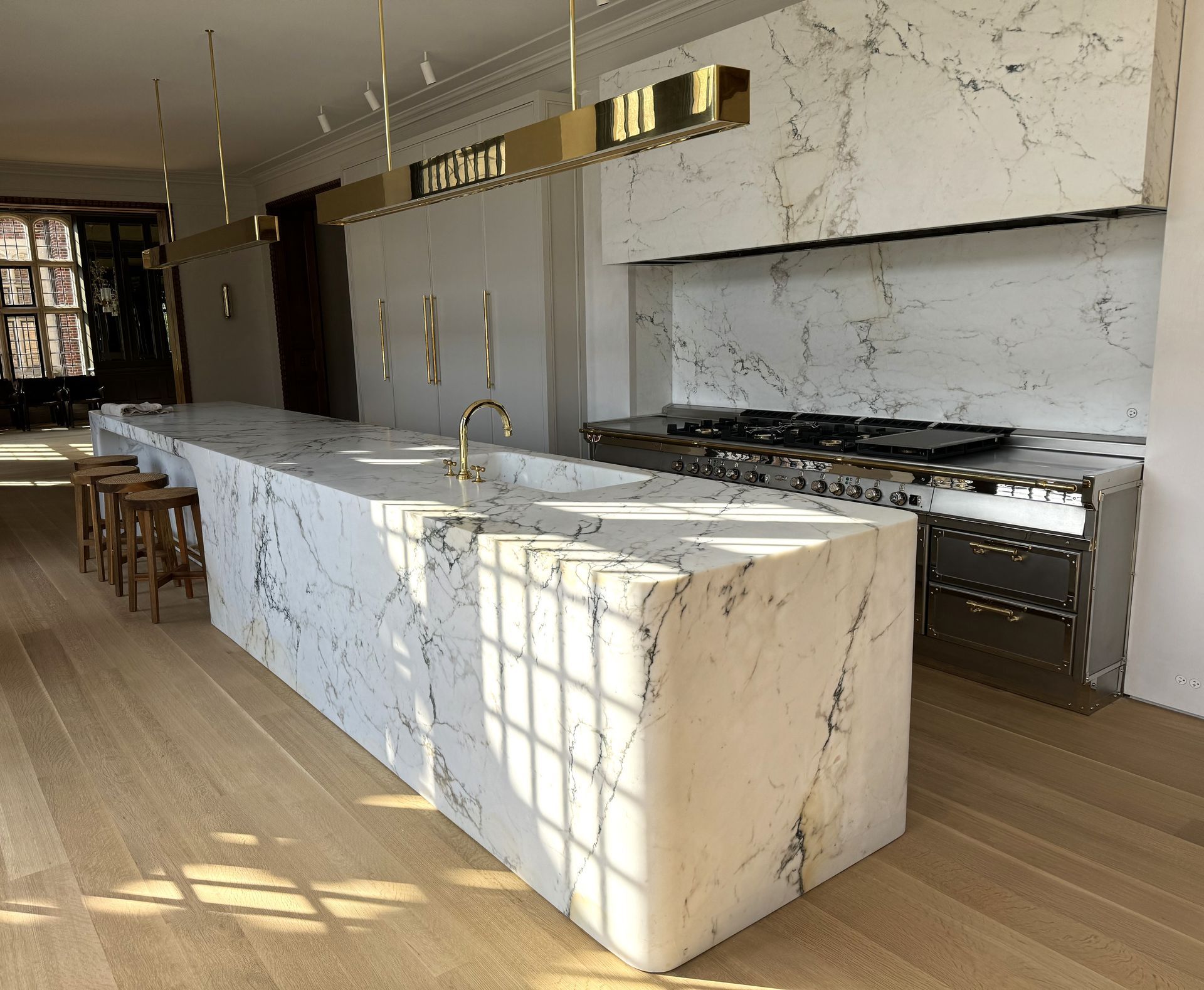 Three bottles of champagne are sitting on ice next to a sink
