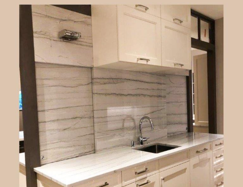 A kitchen with white cabinets and a sink