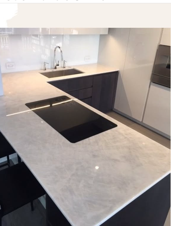 A kitchen with two sinks and a stove top oven