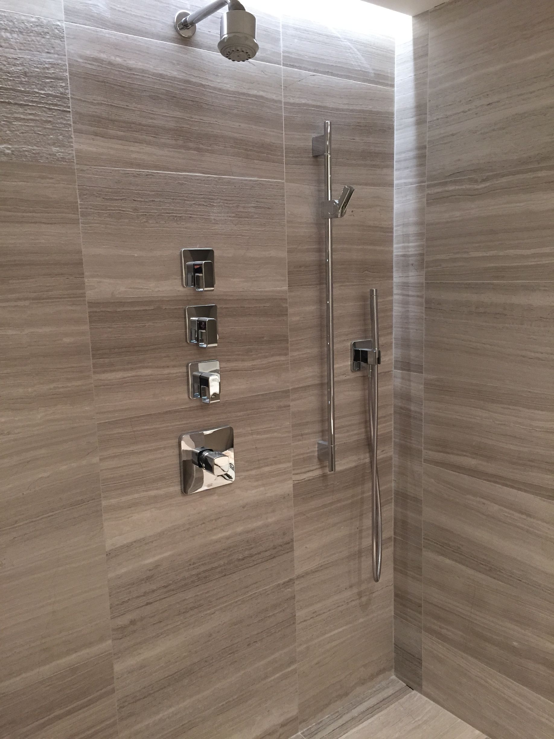 A shower with a shower head and a handheld shower head.