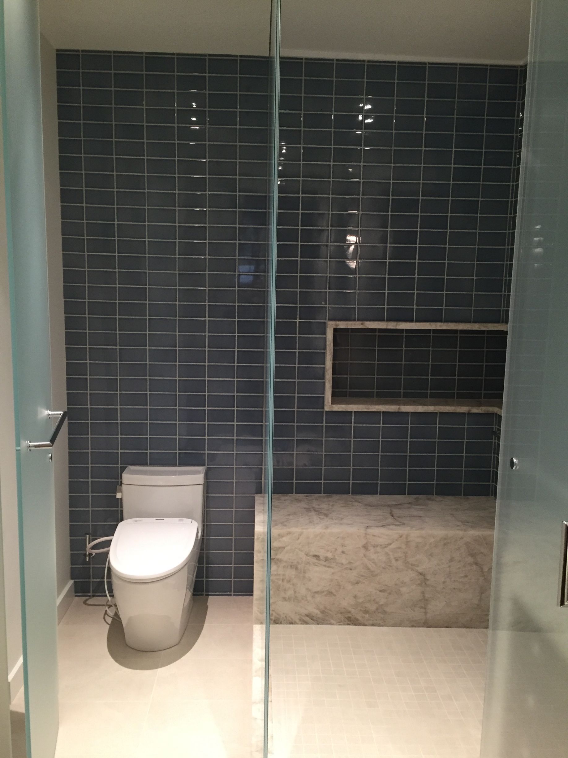 A bathroom with a toilet and a shower stall