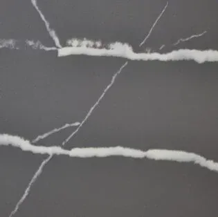 A close up of a gray marble counter top with white veins.