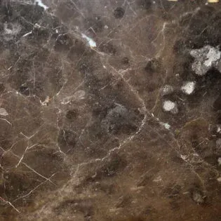 A close up of a brown marble tile with white veins.