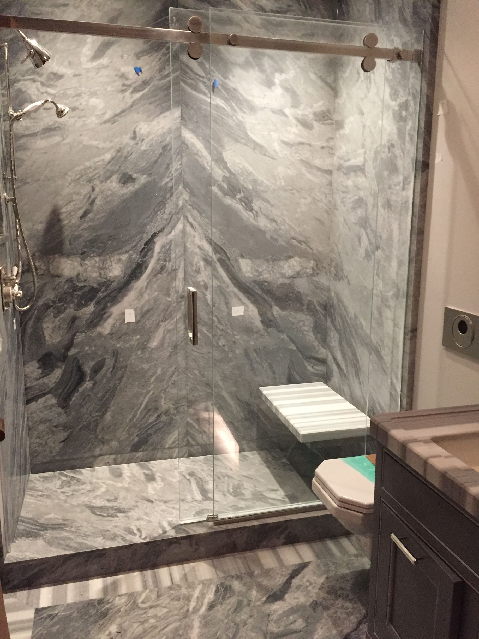 A bathroom with a walk in shower and a toilet.